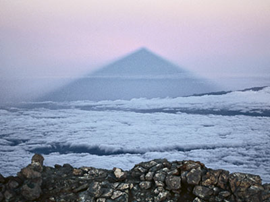 Gespenstisch wirft der Vulkan allabendlich seinen Kegelschatten auf Wolken und Meer.