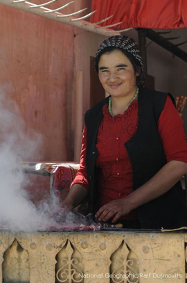 Scheue Schönheit: Eine Kirgisin am Grill. Bild: National Geographic/Ralf Dujmovits.